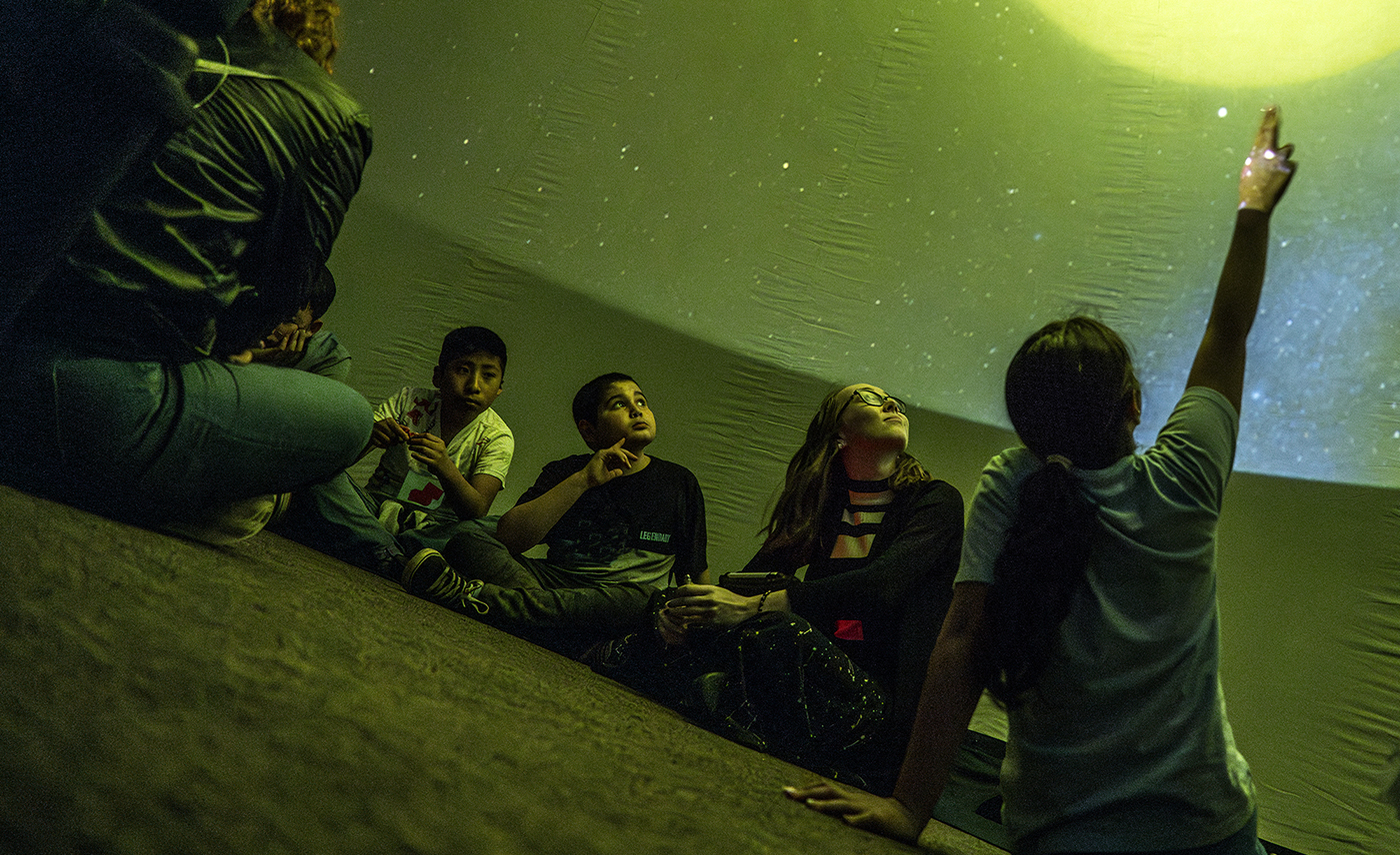 Young people watch a planetarium show