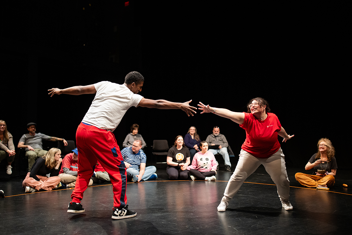 Two participants touch hands during a Shakespeare and Autism performance