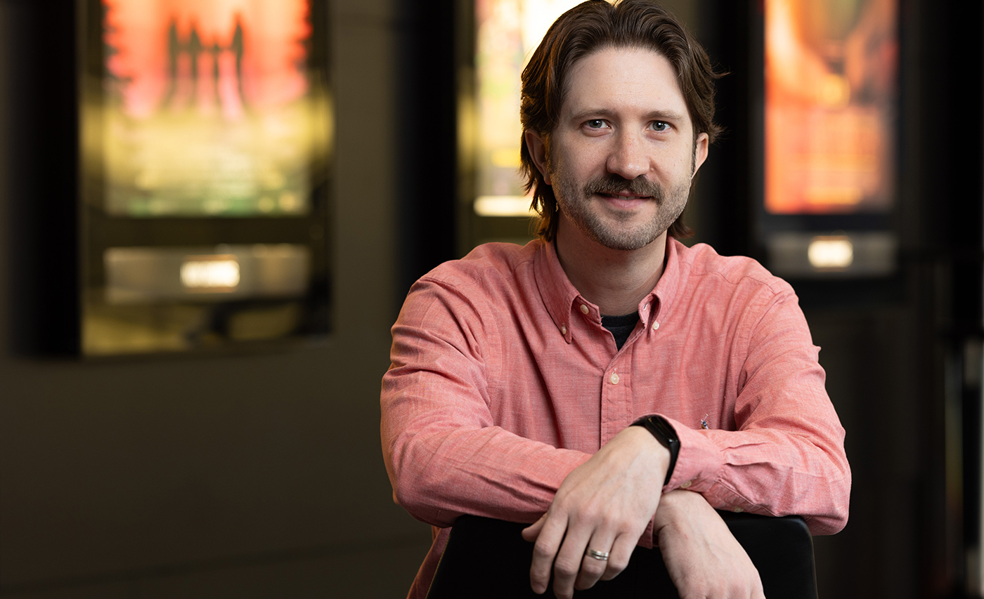Ohio State School of Communications faculty Matt Grizzard poses with movie posters behind him
