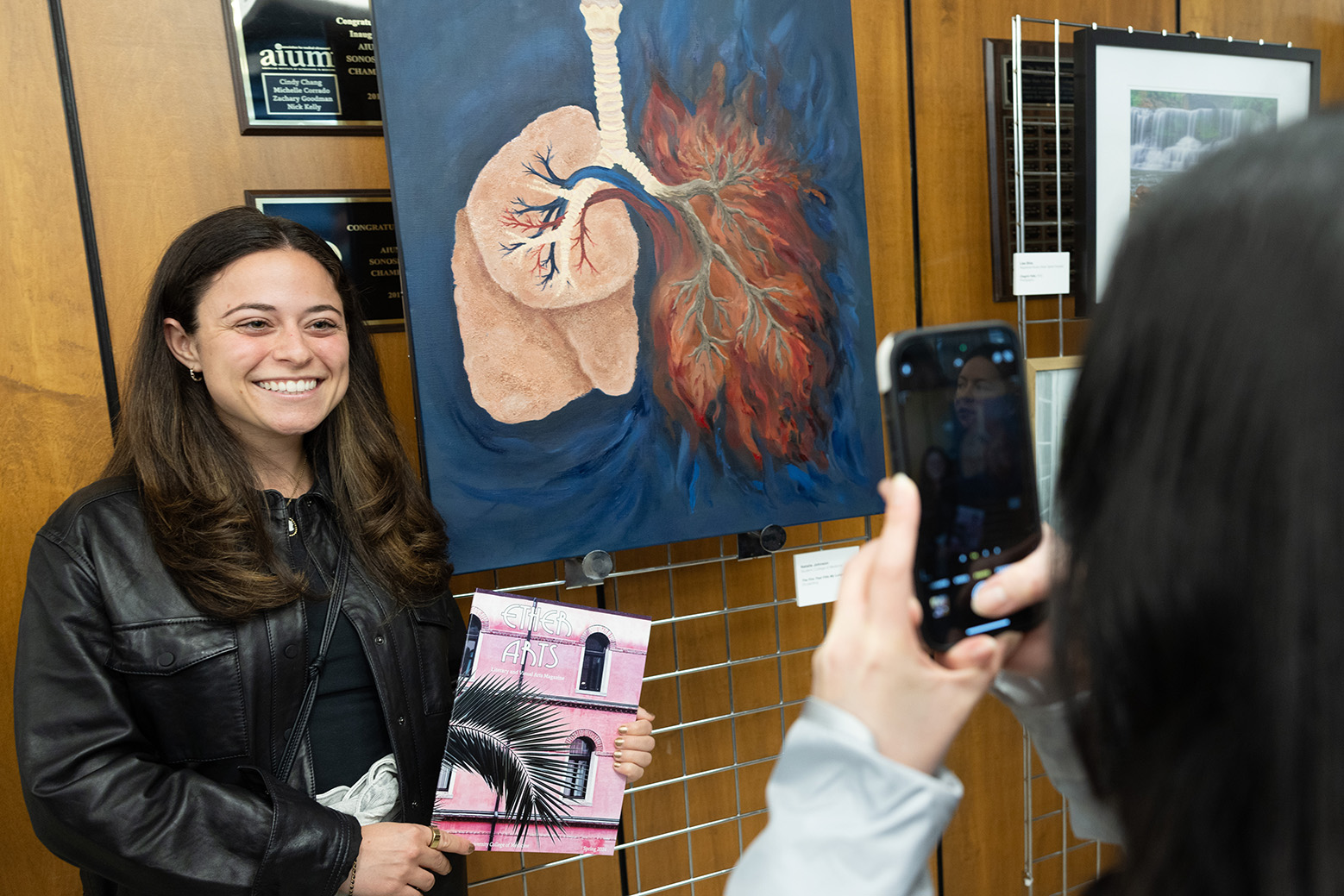 Natalie Johnson posing next to her art piece for a photo