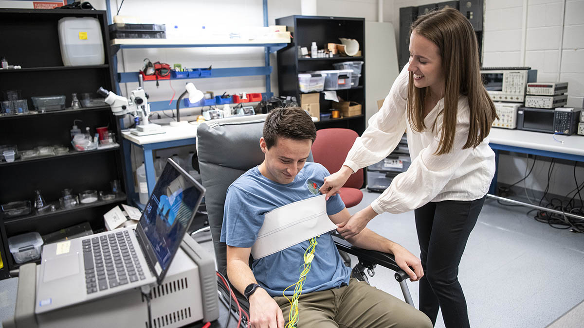 A student secures a wearable device on another student in Ohio State's ElectroScience Laboratory.