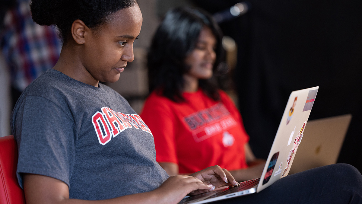Two students work on laptops.