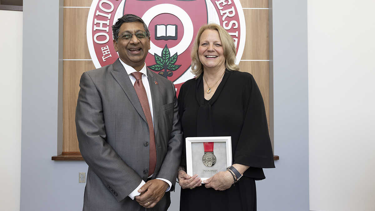 Janet Box Steffensmeier, holding the Agostini Prize, poses with Ohio State President Ravi V. Bellamkonda
