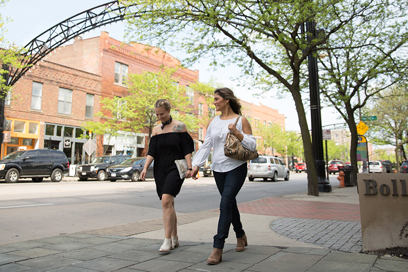 Two people walking on a sidewalk in the Short North