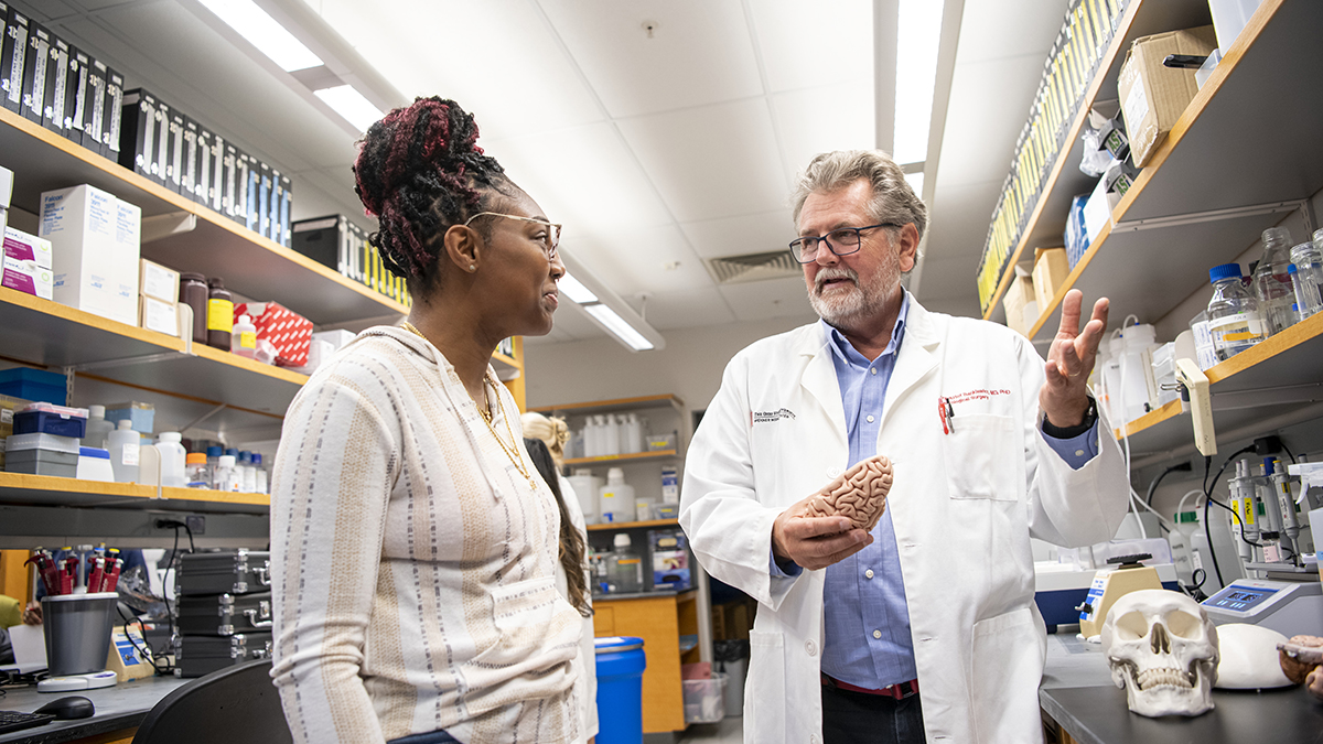 Dr. Krystof Bankiewicz speaking with another person in a medical facility