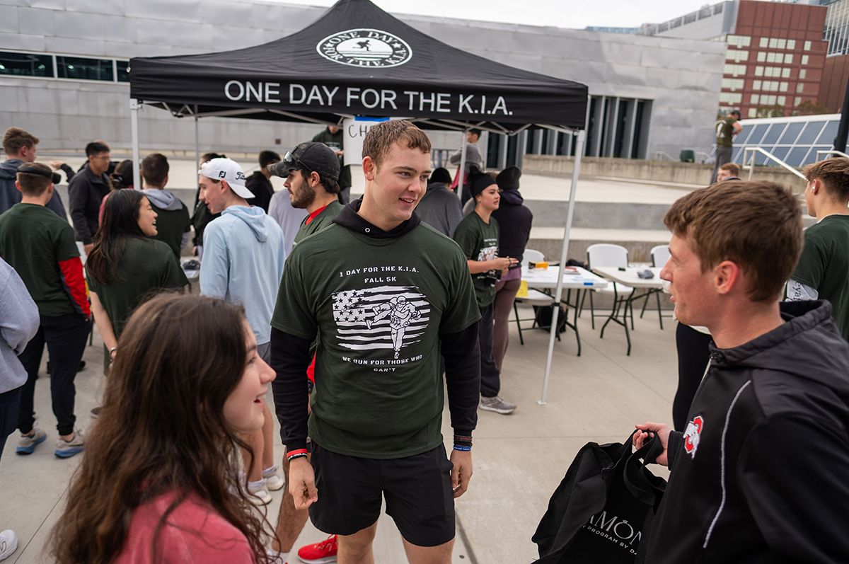 Ohio State student TJ Hill, a third-year biochemistry major, speaks with fellow participants in the One Day for the KIA 5K. Hill is president of the student organization.