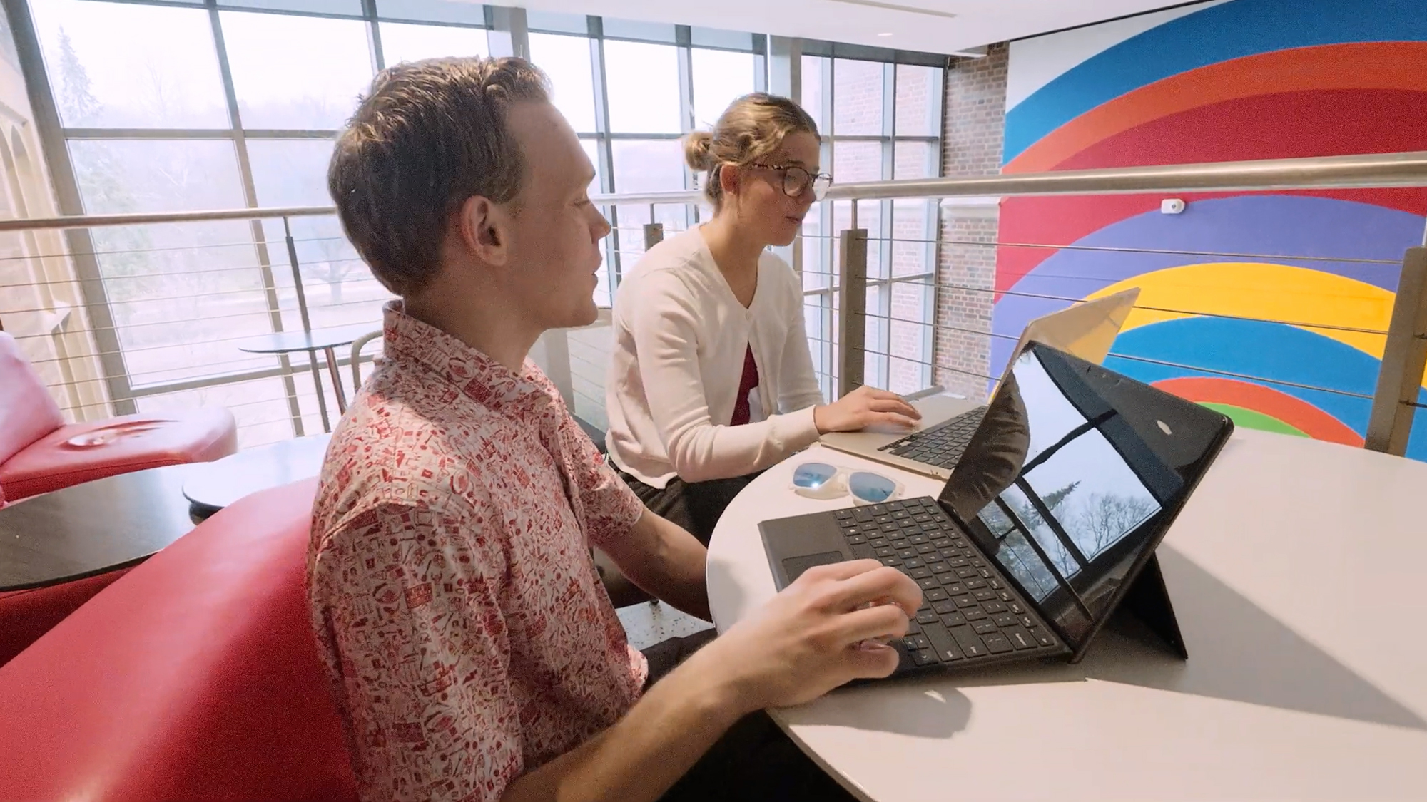 Ohio State student Jack Drake works on a laptop as a fellow student sits beside him