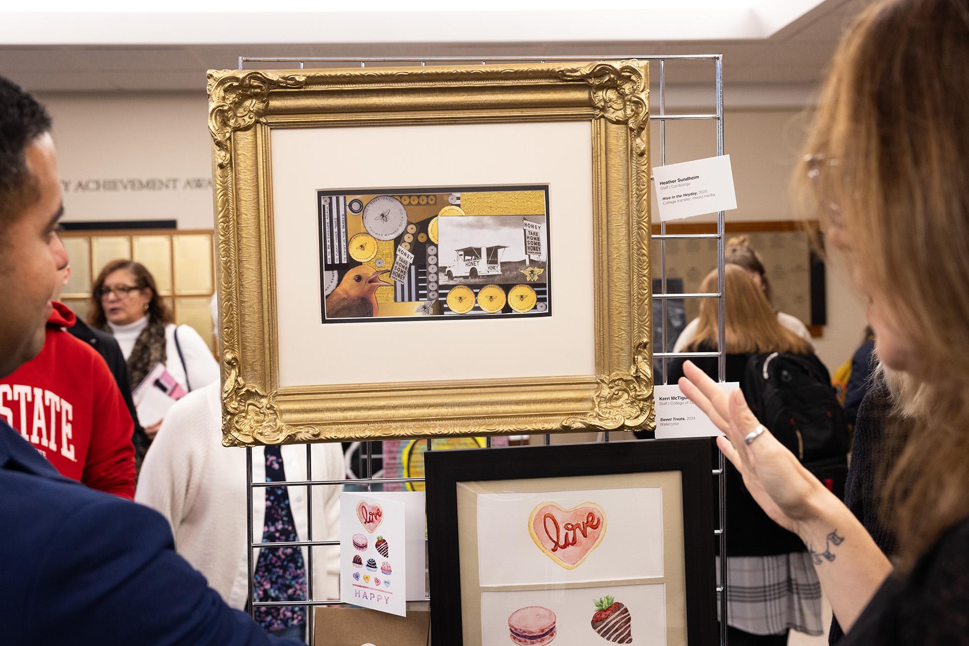Looking over the shoulder of two people examining framed art