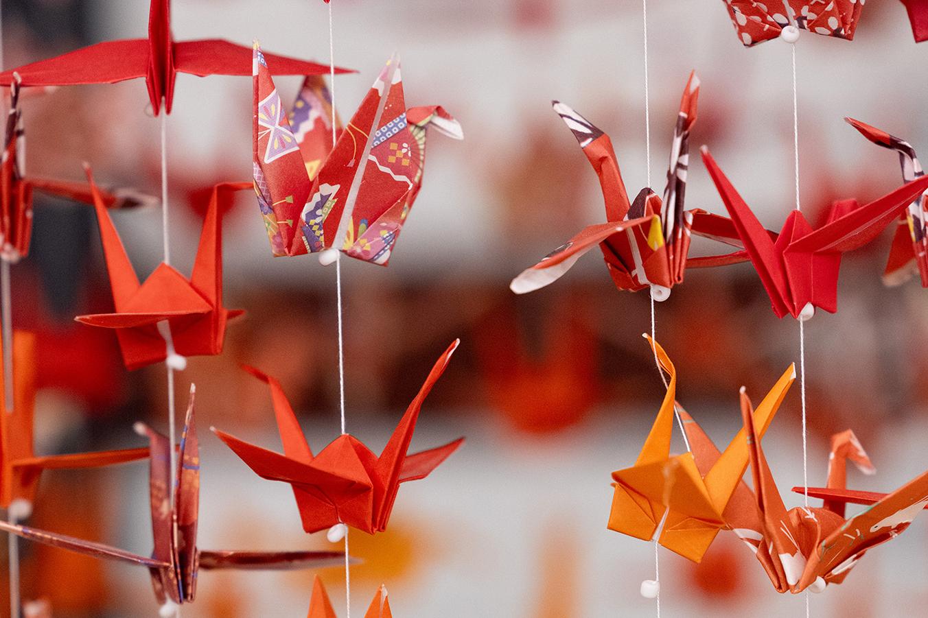 Red, yellow and orange paper cranes on string