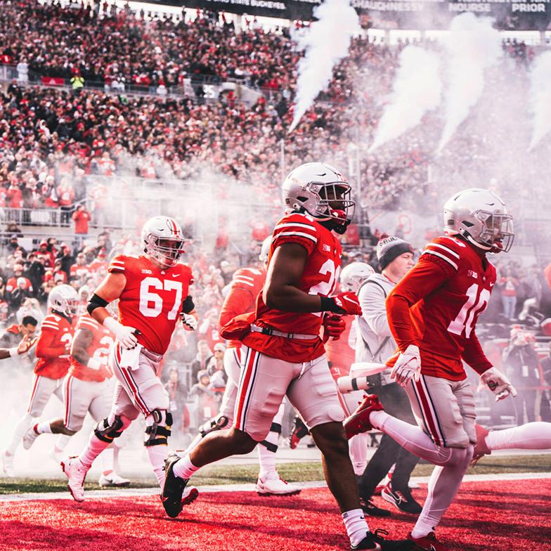 Members of the Ohio State football team run onto the field before a game
