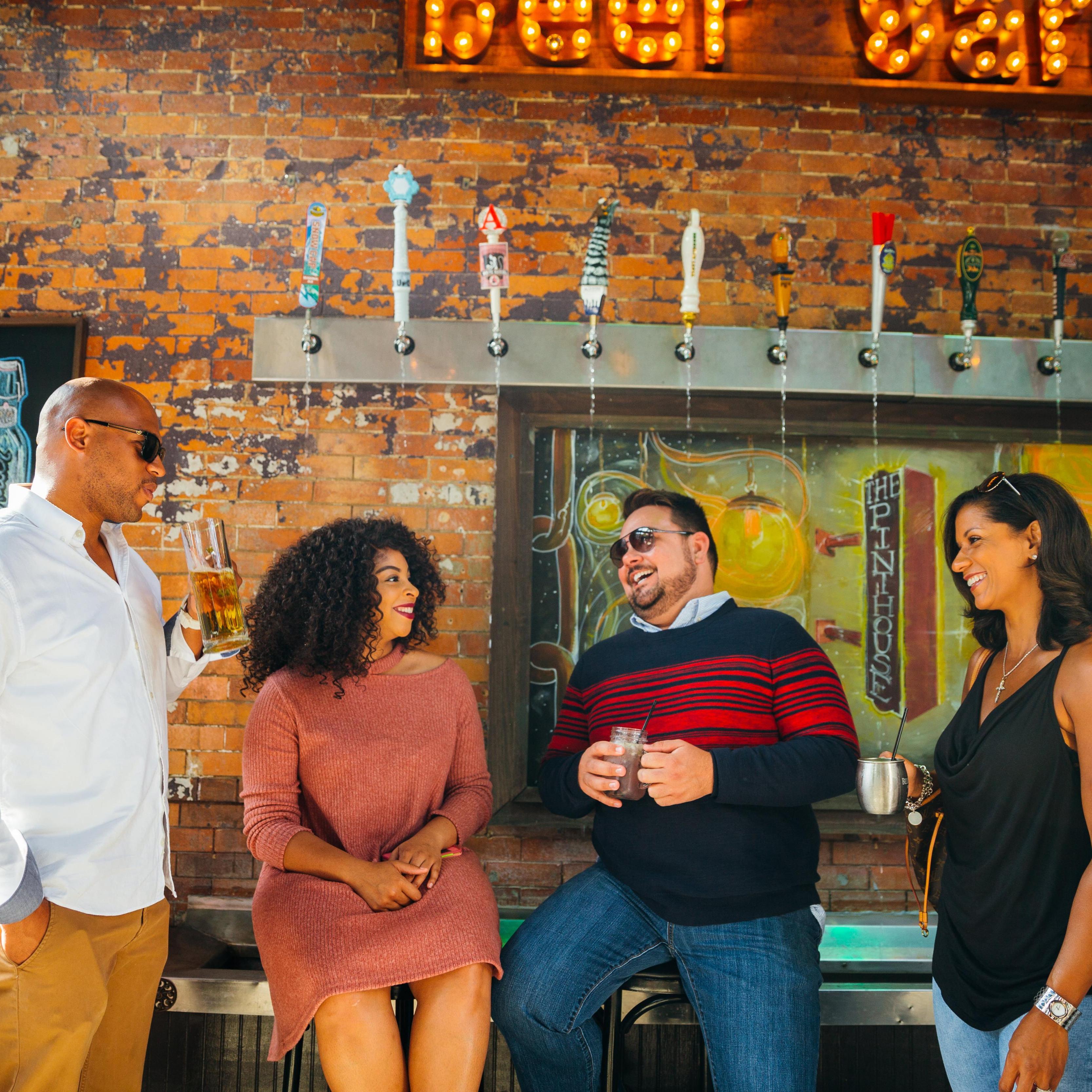 Four people enjoying beverages at The Pinthouse. Photo by Experience Columbus; Levi Ely