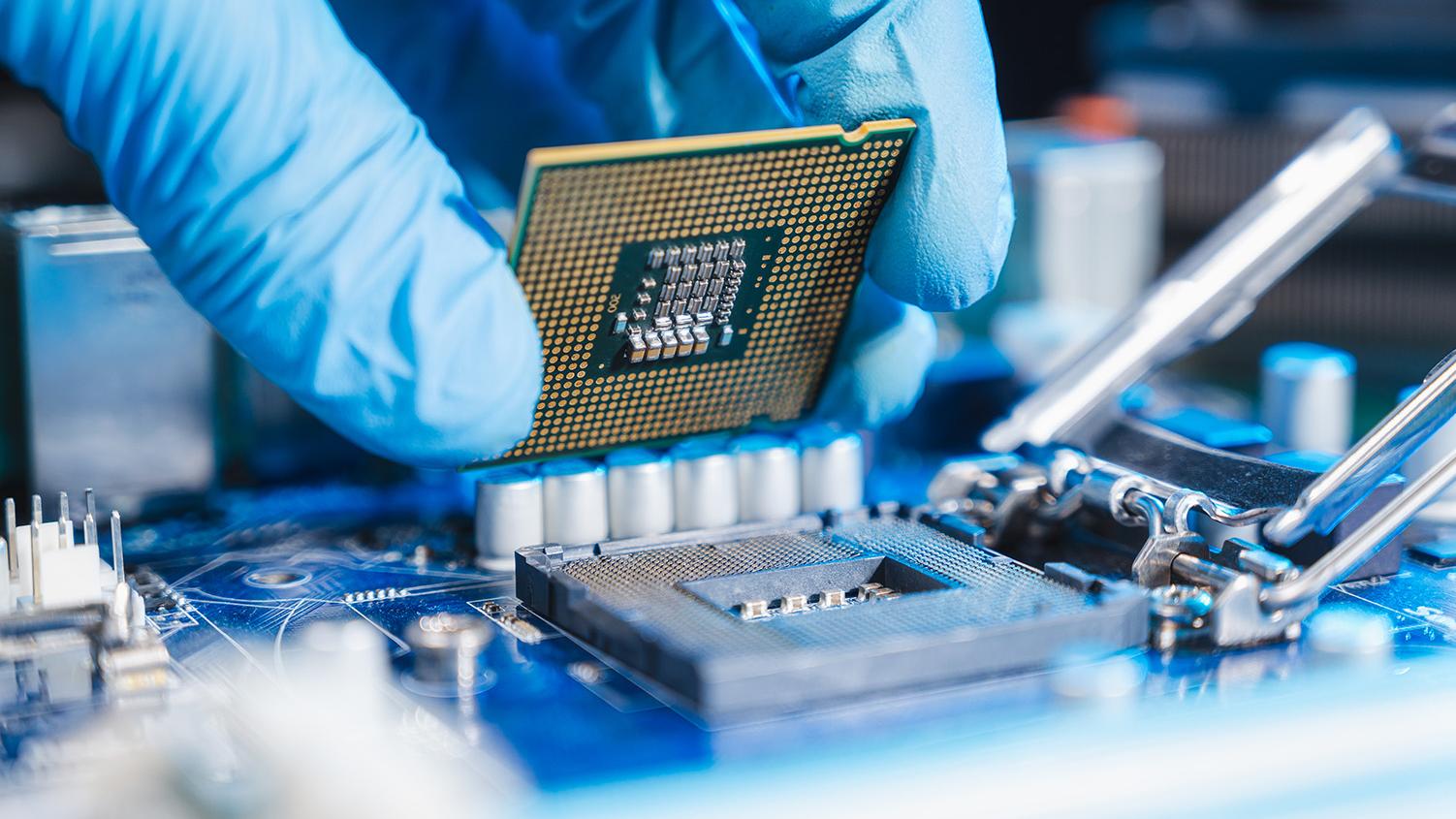 Person wearing gloves adding microelectronic chip to hardware