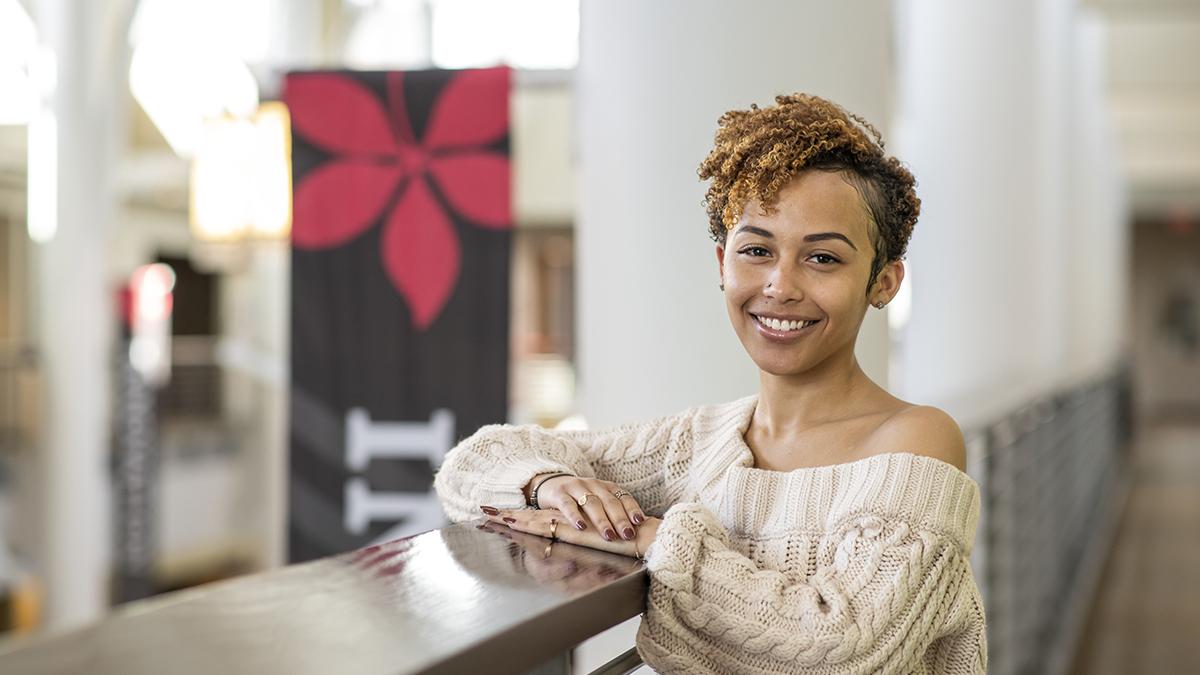McKenna Hensley poses for a portrait in the Ohio Union with a Buckeye leaf banner in the background