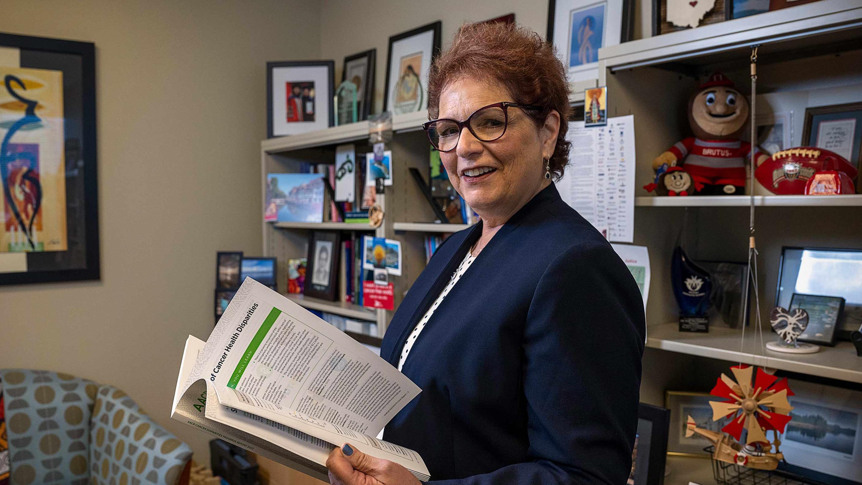 Dr. Electra Paskett holding a booklet