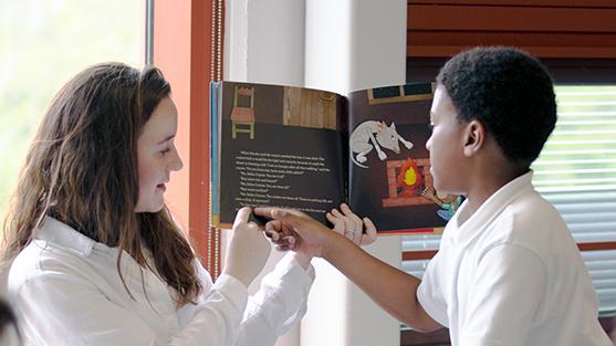 An adult and child reading a book